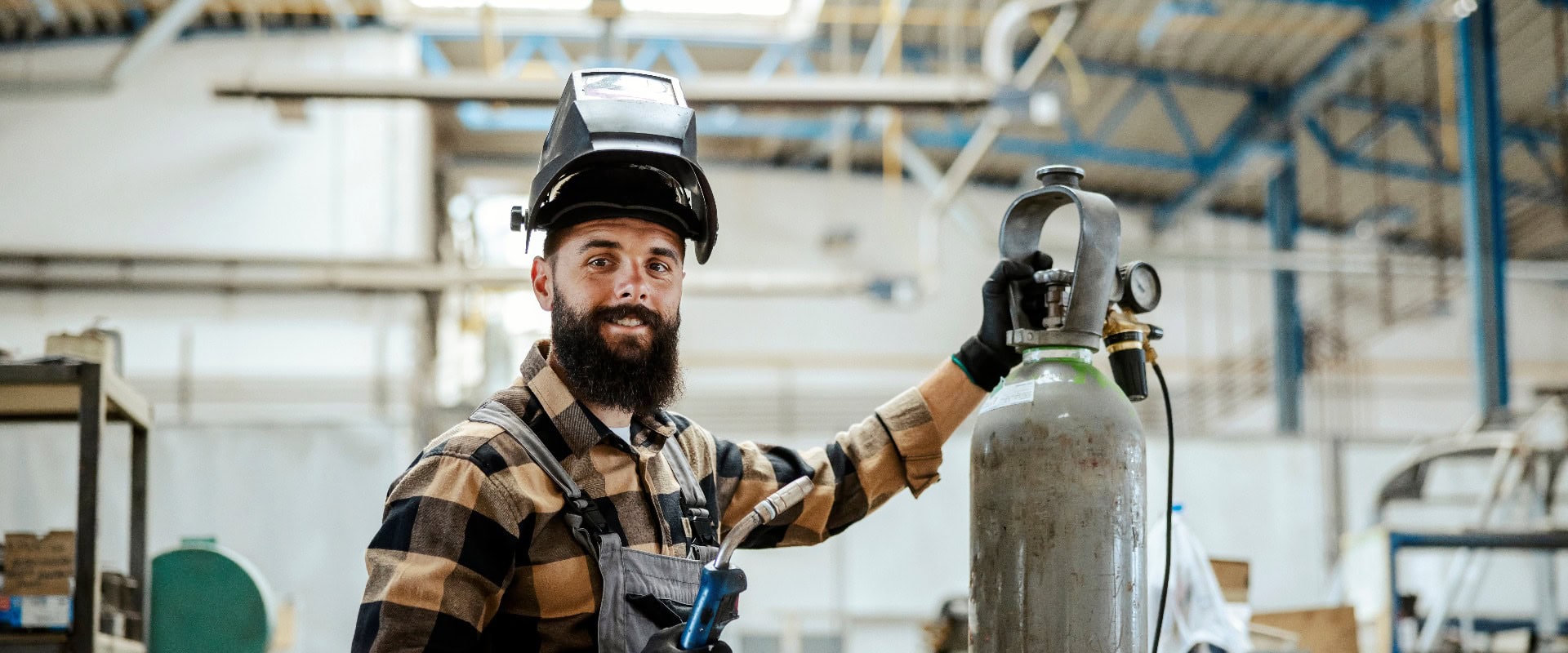 Arbeiter mit einer Schweißmaschine in einer Werkstatt.