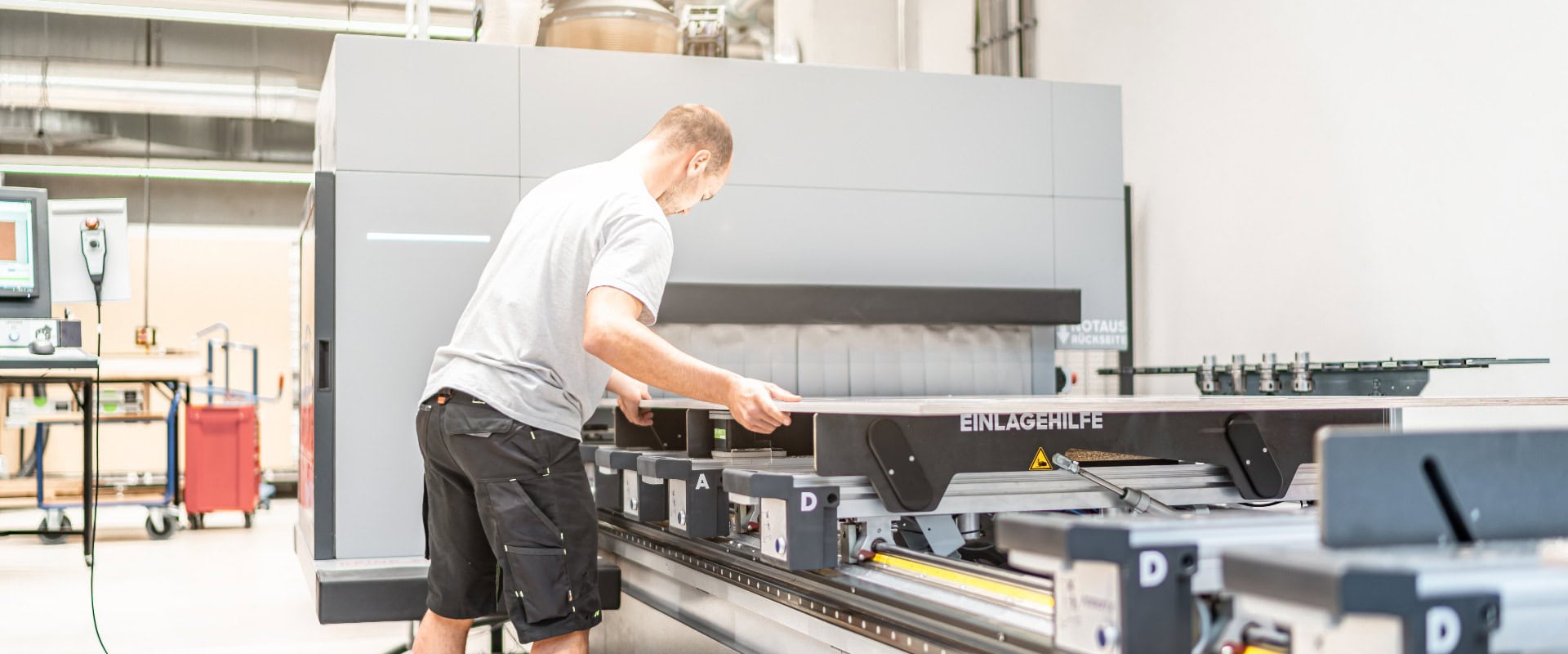 CNC Fräser legt die zu bearbeitende Platte in das CNC-Bearbeitungszentrum